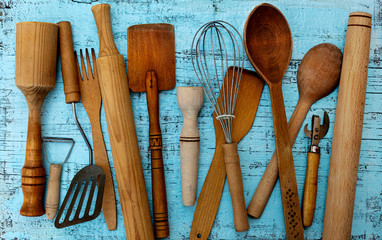 Vintage old kitchen utensils on a blue wooden background.
