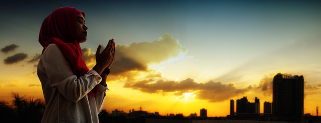 Silhoueitte of young muslim woman pray with beautiful sunset/ sunrise in background of Fuji mount