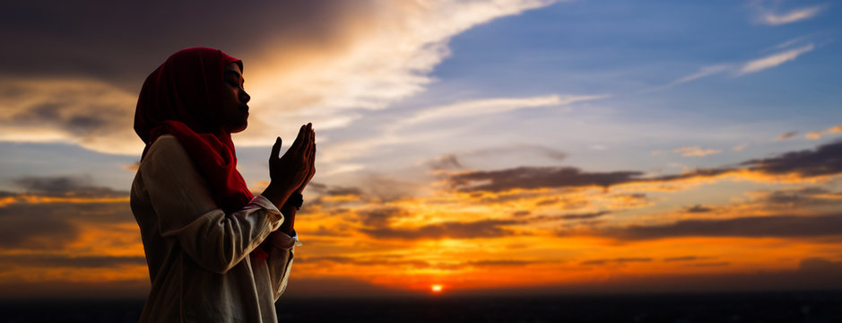 Silhoueitte Of Young Muslim Woman Pray With Beautiful Sunset/ Sunrise In Background