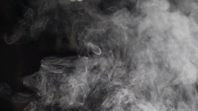 Closeup of white smoke in slow motion on black background. hd