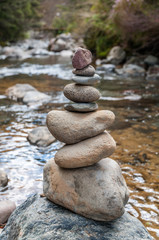 Fototapeta na wymiar Cairn of balanced stones by the riverside
