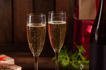 Christmas holiday table with glasses and a bottle of wine of champagne. Eve of new year, preparation and laying of a wooden holiday table