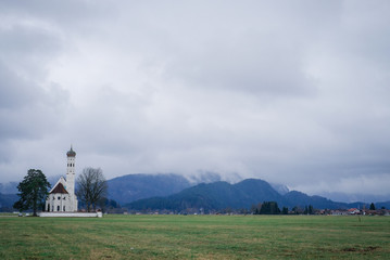 Beautiful view of St. Coloman white church in Schwangau, Bavaria, Germany, Alps mountains.
