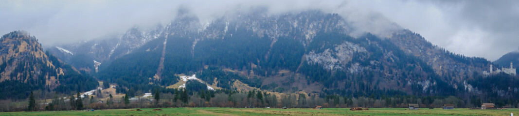 Beautiful view of world-famous Neuschwanstein Castle on the mountain in rainy day, southwest Bavaria, Germany  