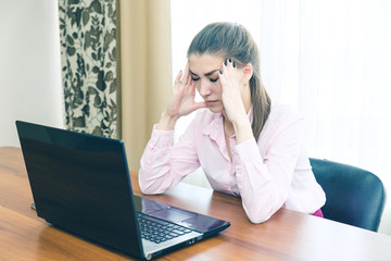 Young businesswoman is experiencing stress in the workplace. Headache from overload in the workplace.