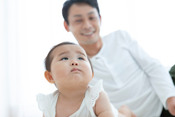 寝転ぶ父親と赤ちゃん