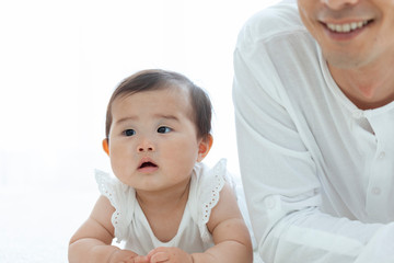 寝転ぶ父親と赤ちゃん
