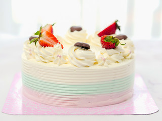 Vanila cake covered with butter cream and decorated with sliced strawberry