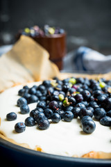 Fresh cheesecake with wild blueberries on the rustic background. Selective focus. Shallow depth of field.