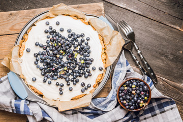 Fresh cheesecake with wild blueberries on the rustic background. Selective focus. Shallow depth of field.