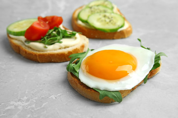 Slices of bread with different toppings on grey marble table