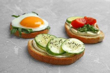 Slices of bread with different toppings on grey marble table