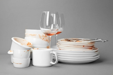 Set of dirty dishes on grey background