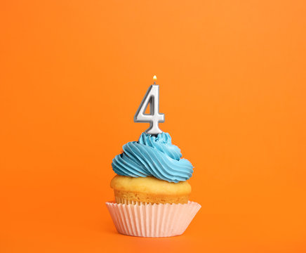 Birthday cupcake with number four candle on orange background