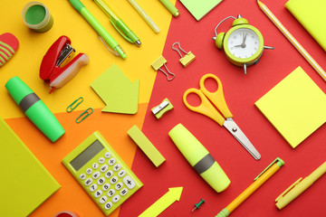 Different bright school stationery on color background, flat lay