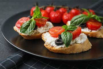 Plate of delicious tomato bruschettas on table, closeup