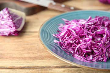 Shredded red cabbage on wooden table, closeup