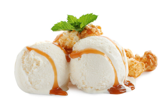 Scoops of delicious ice cream with caramel sauce, mint and popcorn on white background