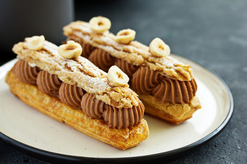 Homemade eclair with chocolate and nuts. Pastry.