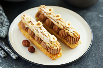 Homemade eclair with chocolate and nuts. Pastry.