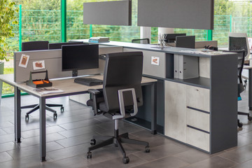 Desks are located in a modernly furnished office