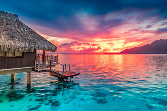 Stunning colorful sunset sky with clouds on the horizon of the South Pacific Ocean. Lagoon landscape in Moorea. Luxury travel.