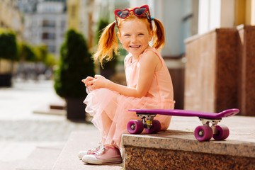 Charming red haired girl smiling on camera