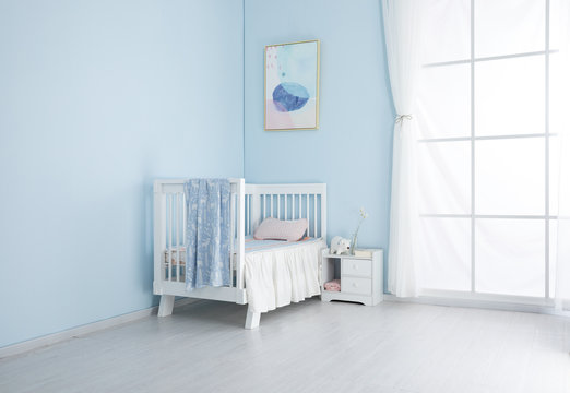Children's bed in an empty room, lit by sunlight.Cool mat and baby sleeping bag feel comfortable and smooth cloth surface