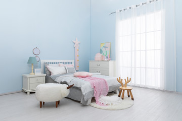 Children's bed in an empty room, lit by sunlight. There are white curtains, mats and jacquard...