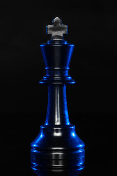 Chess figures on black background with blue backlight