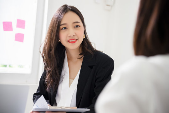 A young attractive asian woman is interviewing for a job. Her interviewers are diverse. Human resources manager conducting job interview with applicants in office