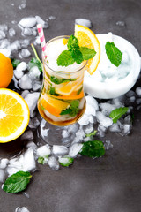 Mohito lime and orange drinks on black background.