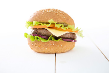 Tasty hamburger on the white wooden table.