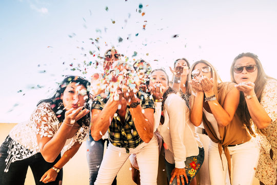 Happiness and joyful concept - group of happy women people celebrate. all together blowing confetti and having fun - new year eve and party event for group of beautiful girls -white clear  background