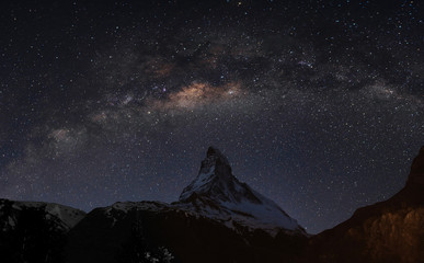 Panoramic Matterhorn mountain at night in Switzerland with starry sky and milky way