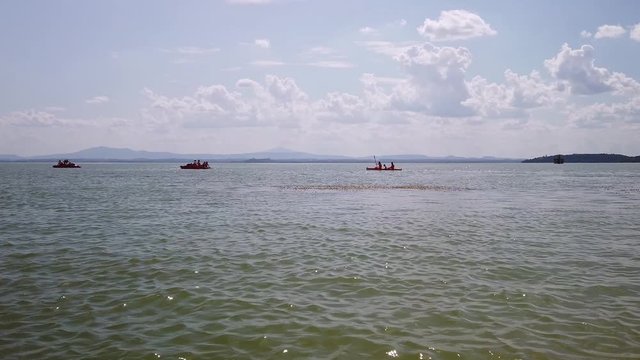 Sualzo beach, Umbria, Italy with tourists using pedalos and canoes on lake Trasimeno