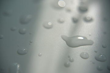 drops of water on white surface with shadow