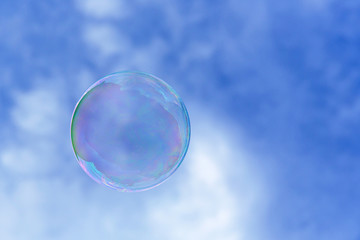 a single bubble blowing in the air against blue sky. Close up