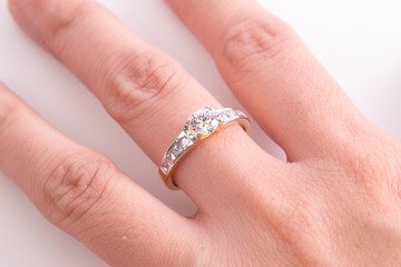Close up of elegant diamond ring on the finger with white background. Diamond ring.