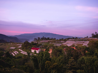 Fototapeta premium Landscape of agricultural areas of people in Fang district, Chiang Mai, Thailand from the top of the mountain in the evening on sunset background.