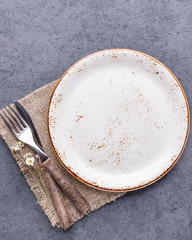 Empty  plate and cutlery on a napkin. Closeup. Top view