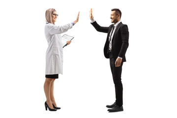Young female doctor making high-five gesture with a businessman