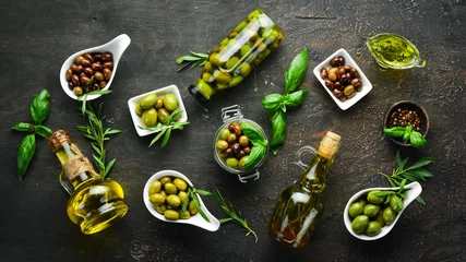 Tuinposter Olijven, olijfolie, specerijen en kruiden op de rustieke achtergrond. Bovenaanzicht. Vrije ruimte voor uw tekst. © Yaruniv-Studio
