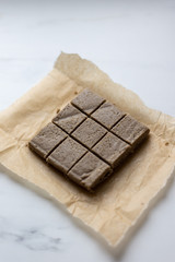 Portion of halva with vanilla and sunflower seeds on marble background with copy space