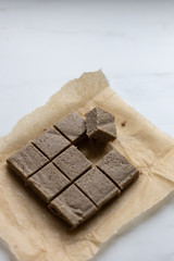 Portion of halva with vanilla and sunflower seeds on marble background with copy space