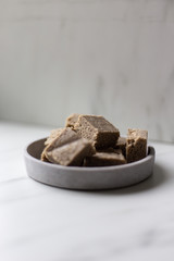 Portion of halva with vanilla and sunflower seeds on marble background with copy space