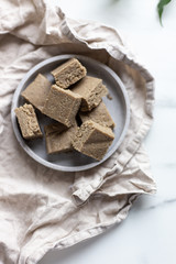 Portion of halva with vanilla and sunflower seeds on marble background with copy space