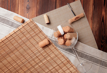 glass of wine and wine corks on a dark background.
