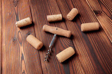 Corkscrew with cork. On a wooden background. - Image