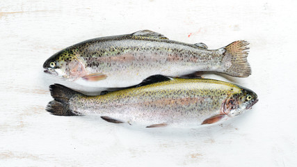 Raw fish trout on a white wooden background. Top view. Free space for your text.